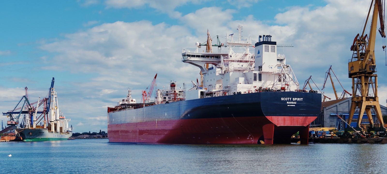Large tanker vessel at sea near port infrastructure